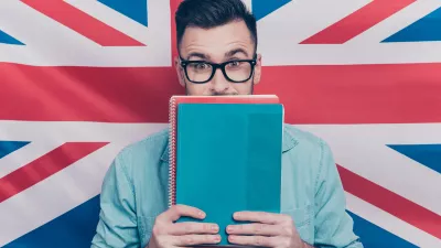 Mann mit Büchern vor englischer Flagge