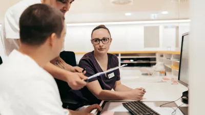 drei Studierende besprechen sich im Pflegebüro