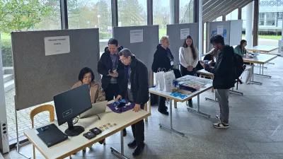 Staff Exchange Teilnehmer*innen stellen ihre Hochschule im Foyer des Hauptgebäudes vor.