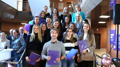 Gruppenfoto von Absolvent*innen bei der Abschlussfeier der Fakultät S. Amerikanische Einstellung.