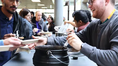 Besucher*innen probieren Nationalgerichte am Stand von einem Studierenden aus Südafrika.