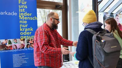 Zwei Studierende informieren sich an einem Messestand.