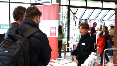 Zwei Studierende stehen vor einem Messestand.