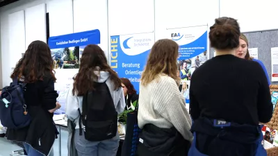 Mehrere Personen stehen an einem Messestand. 