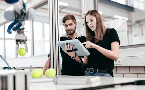 Studierende mit Roboter.