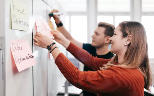 Studentin schreibt an Flip Chart.