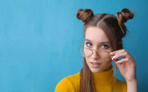 Junge Frau mit Brille blickt in die Kamera