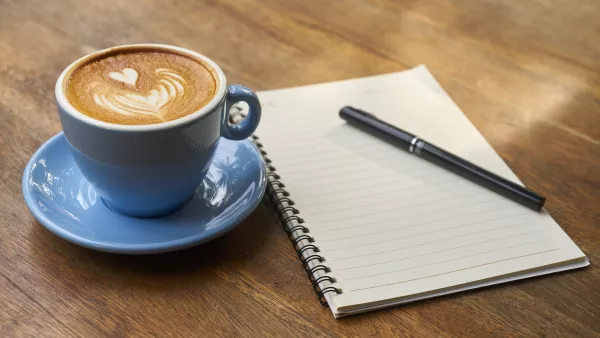 Eine Tasse Kaffee neben einem Block mit Stift