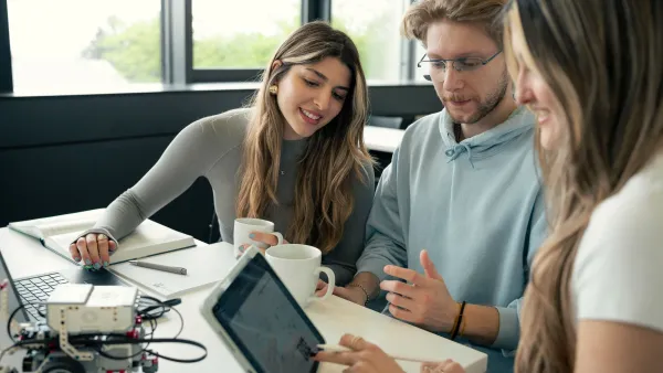 Gruppe Studierender betrachtet Legoroboter