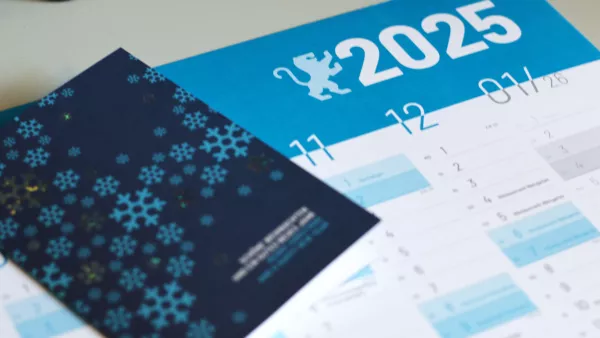 Auf dem RWU Wandkalender 2025 liegt eine RWU-Weihnachtskarte.