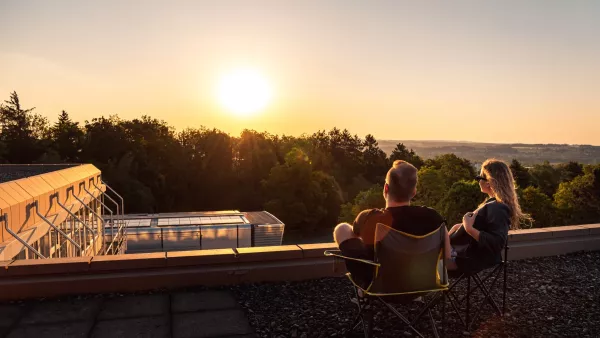 Studierende sitzen auf dem Dach des Hauptgebäudes und blicken im Sonnenuntergang in die Weite des Schussentals