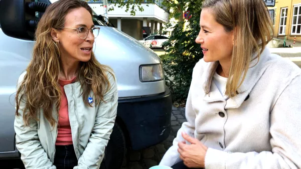 Professorin Julia Wege und Schauspielerin Anneke Kim Sarnau unterhalten sich an einem Holztisch am Set der Krimireihe "Polizeiruf 110"